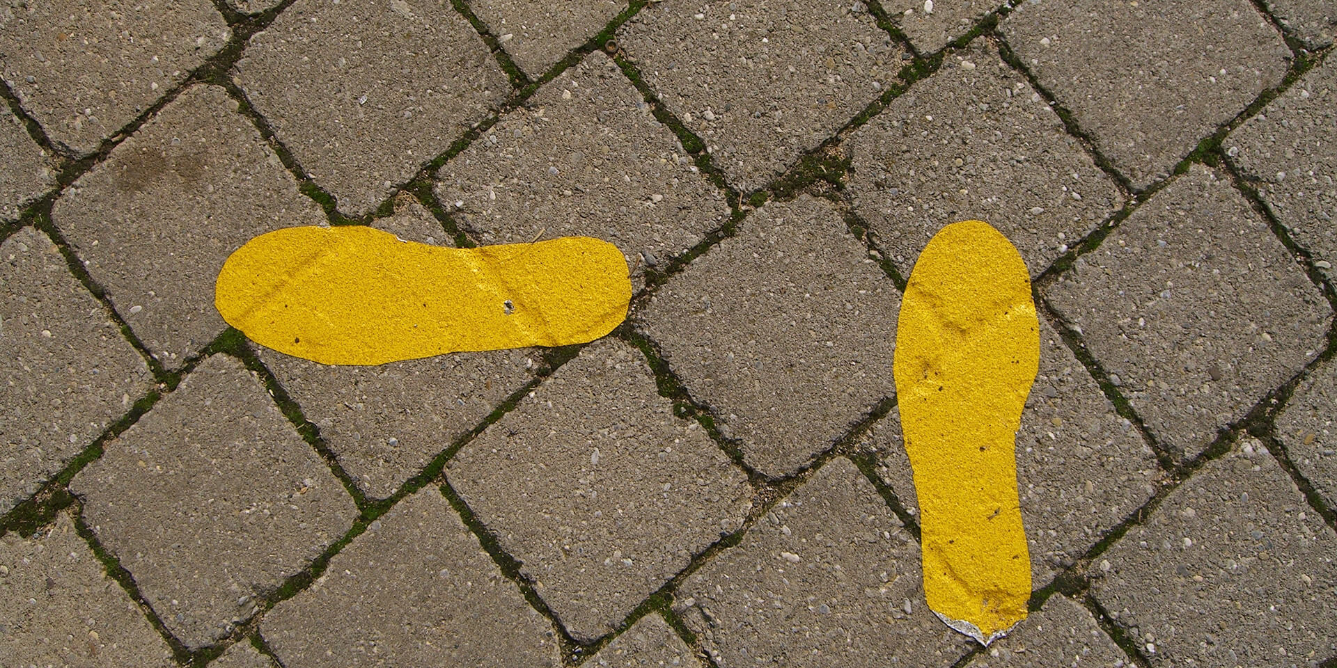 Gelbe Fußspuren auf Asphalt
